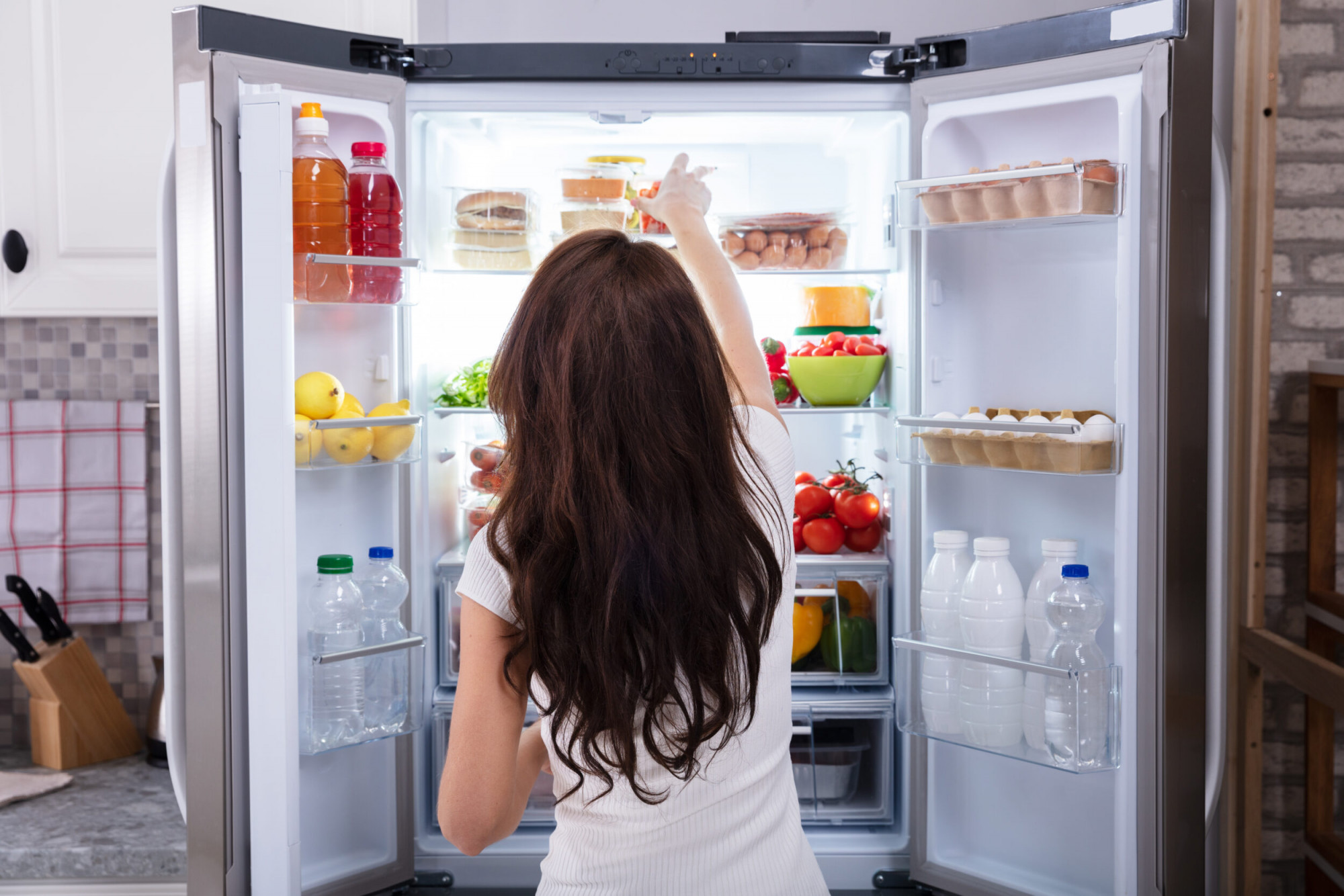 woman tacking food from refrigerator