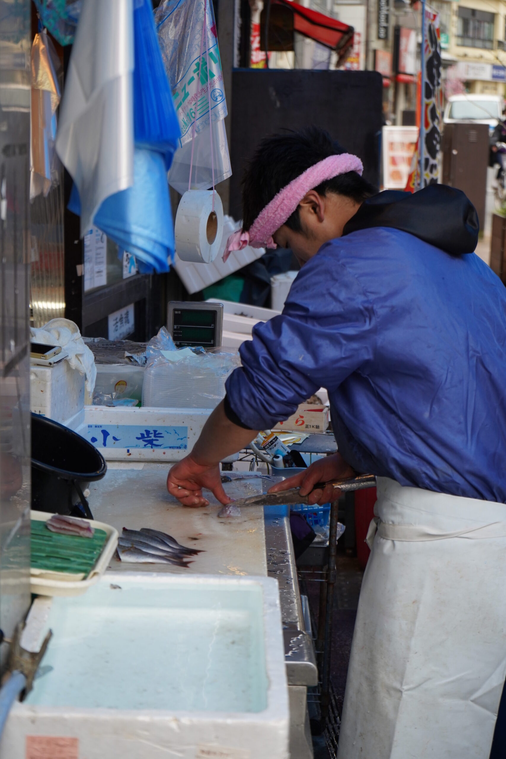 Japanese fish seller cleaning and filleting fish with a deba knife