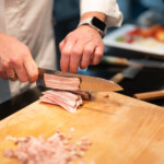 chef cutting meat with sakai kyuba blue gyuto