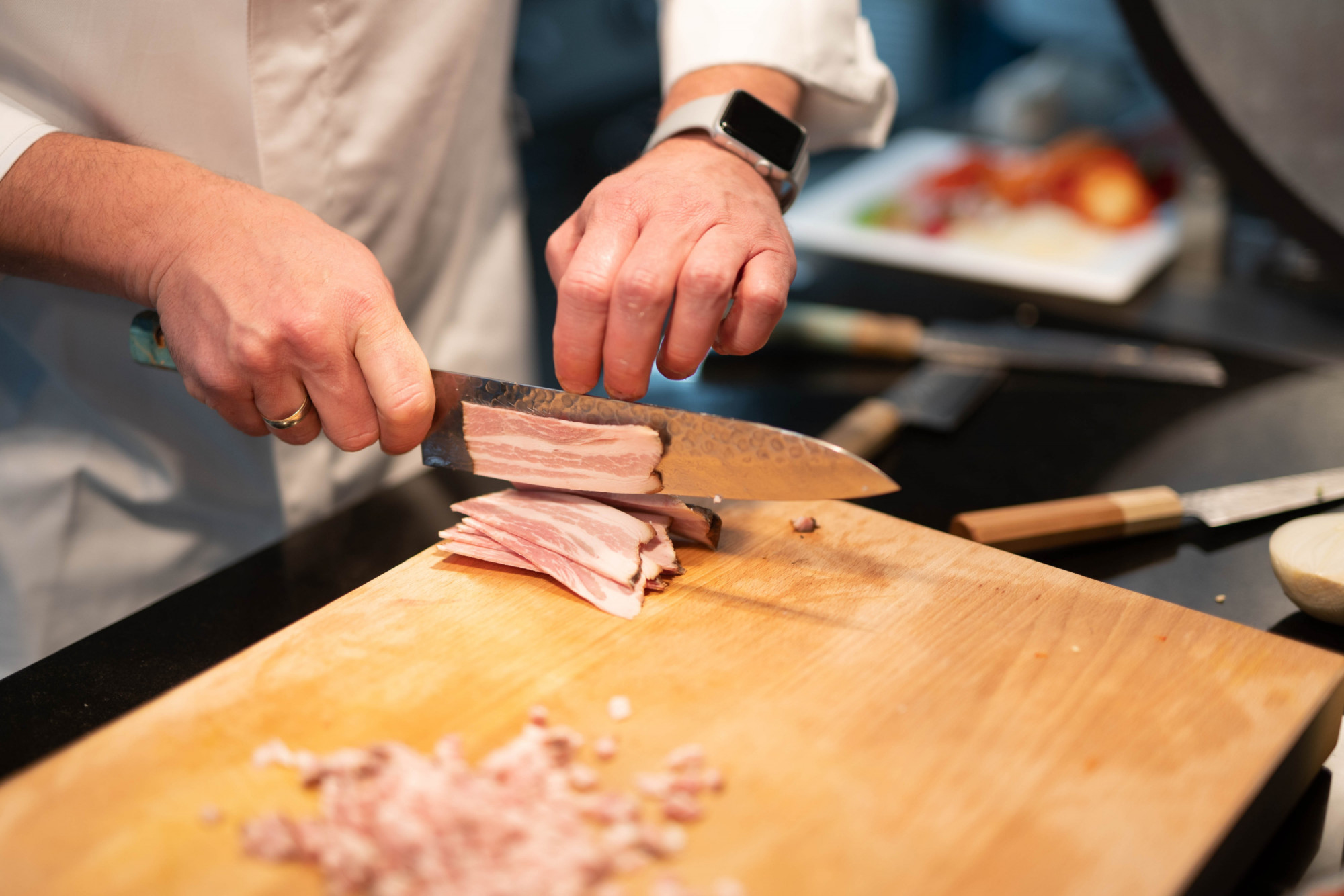 chef cutting meat with sakai kyuba blue gyuto