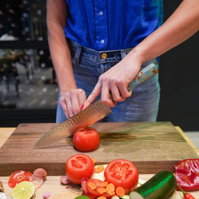 woman cutting with sakai kyuba blue chefs knife