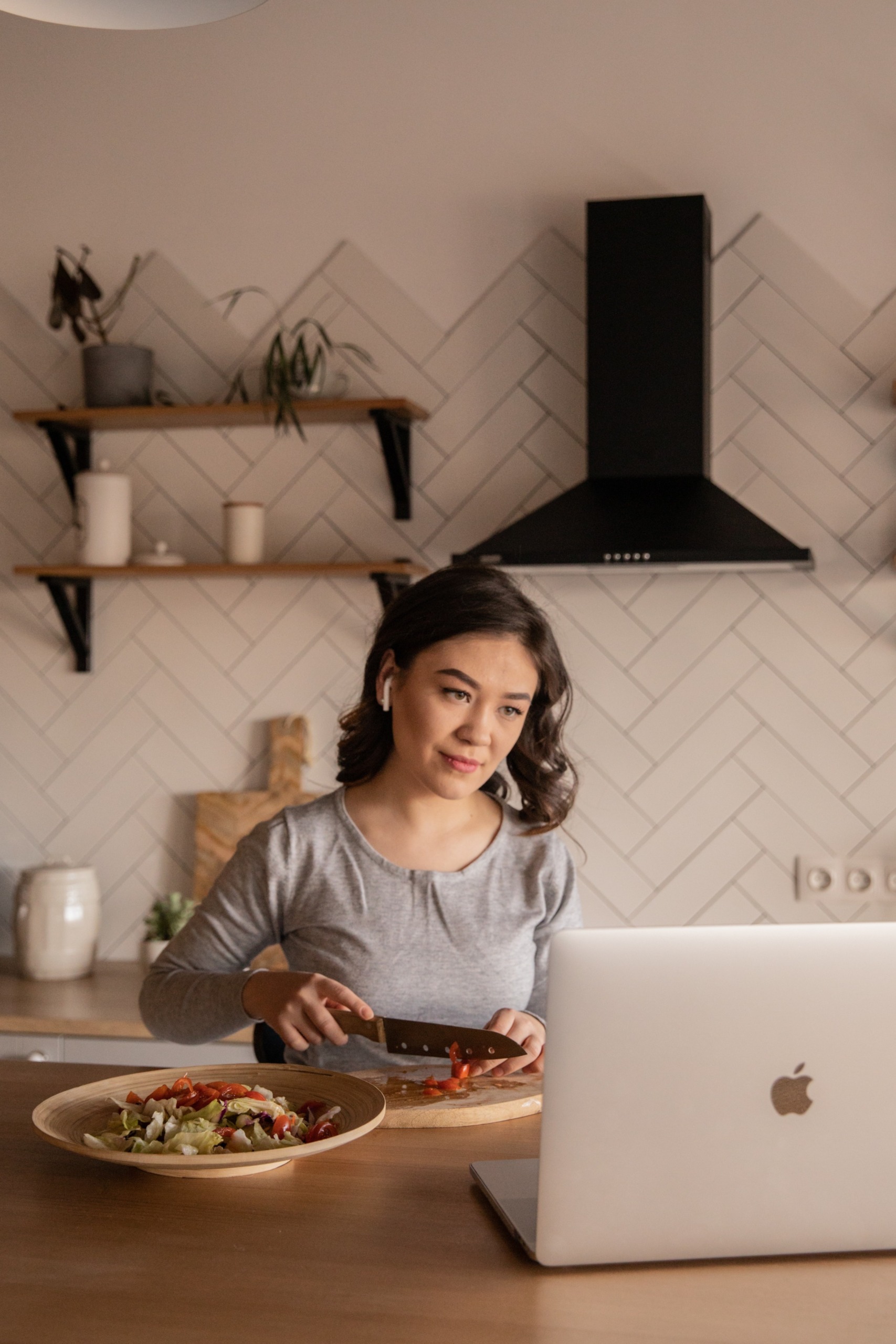 Woman cooking in front of computer screen
